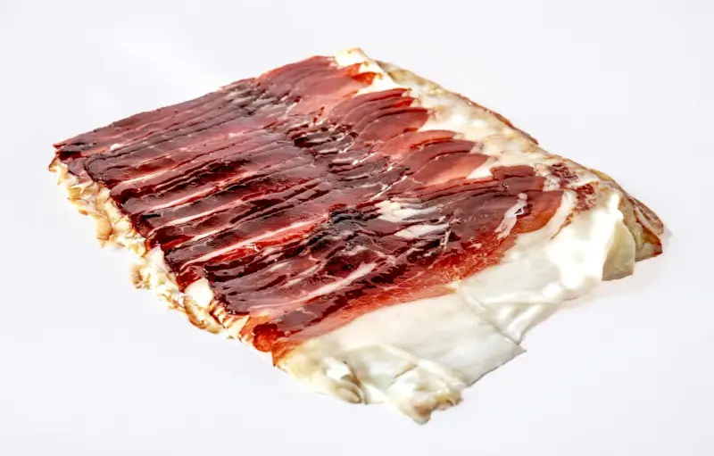 Dünn geschnittener, aromatischer Schinken vom Angler Sattelschwein. Das Fleisch ist dunkelrot mit feinen Fettäderchen und einem weißen Fettrand.
